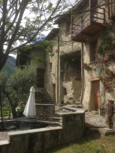 un ombrello bianco seduto fuori da un edificio di Casa Vacanze Roncaiola a Tirano