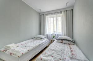 Duas camas num quarto com uma janela em Apartament Marina Dlugie Ogrody em Gdansk