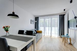 uma sala de estar branca com um sofá e uma mesa em Apartament Marina Dlugie Ogrody em Gdansk