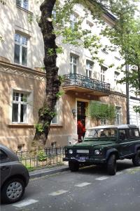 a green jeep parked in front of a building at Art Room Boutique Apartment in Krakow