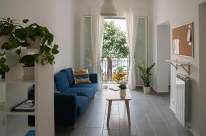 a living room with a blue couch and a window at Dietro il Teatro in Palermo