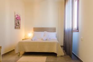 プリノスにあるMainasのベッドルーム1室(白い枕のベッド1台、窓付)