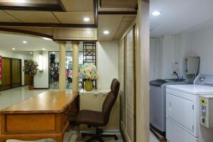 a kitchen with a desk and a table in a room at Nice Palace Hotel in Bangkok