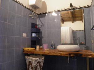 W łazience znajduje się umywalka i lustro. w obiekcie Villa Minteco w mieście Patù