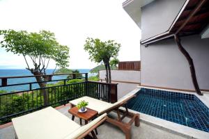 a balcony with a table and chairs and the ocean at Dusit Buncha Koh Tao by Riya Group in Ko Tao