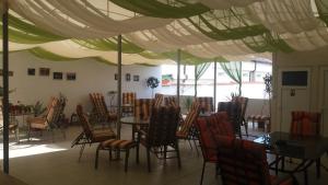 a dining room with tables and chairs under a tent at Casa Panos in 2 Mai