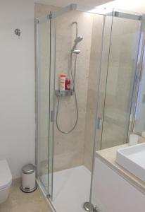 um chuveiro com uma porta de vidro na casa de banho em TP BOMBARDA 5, Lisbon Deluxe Apartment em Lisboa