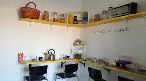 a kitchen with a counter and some chairs and shelves at U'Cuntu affittacamere in Favignana