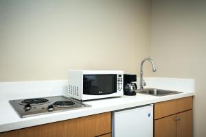 eine Küche mit Mikrowelle, Herd und Spüle in der Unterkunft Diamond Head Inn in San Diego