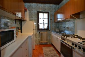 a kitchen with a stove and a sink and a window at Villetta "Il Grillo" in Valdidentro