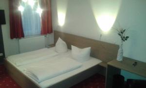 
a hotel room with two beds and a lamp at Gasthof Falter in Straubing
