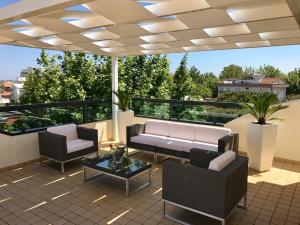 a patio with a couch and chairs on a balcony at Hotel Tenerife in Riccione