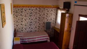 a small bedroom with a small bed and a wall at Divina Presencia in Cafayate