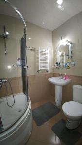 a bathroom with a toilet and a sink and a shower at Gigi Apartments in Batumi