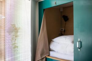 odbicie łóżka w lustrze w pokoju w obiekcie Woodah Hostel w Kopenhadze