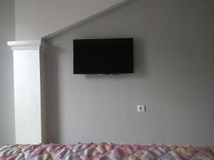 einen Flachbild-TV an der Wand eines Schlafzimmers in der Unterkunft Ivanoski Studios and Guest Rooms in Ohrid