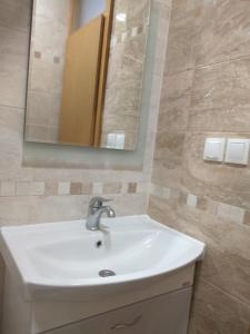 a bathroom with a white sink and a mirror at Ivanoski Studios and Guest Rooms in Ohrid