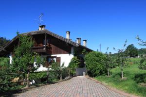 une maison avec une route en briques devant elle dans l'établissement Agritur Chelodi, à Cavalese