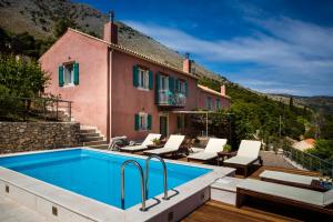 a villa with a swimming pool and a house at Iconic Villas - Villa Rosa in Agia Effimia