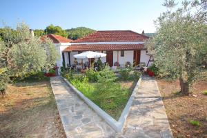 a house with a garden in front of it at Armonia Guesthouse in Panormos Skopelos