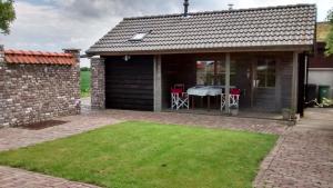 ein Haus mit einer Terrasse mit einem Tisch in der Unterkunft Dijkwoning Cadzand in Cadzand