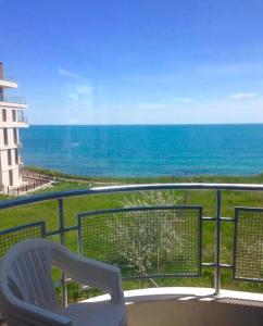 una sedia bianca seduta su un balcone con vista sull'oceano di Apartments Lucky Complex Ravda a Ravda