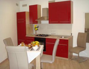 a kitchen with red cabinets and a table and chairs at Apartments Nik in Selce +7 photos