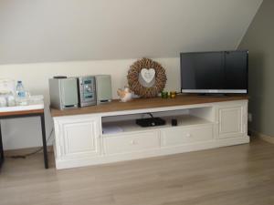 a white entertainment center with a television on top of it at B&B Hoeve 't Geleed in Damme