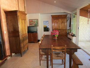 een eetkamer met een houten tafel met bloemen erop bij La Piaule in Saint-Pierre-le-Vieux