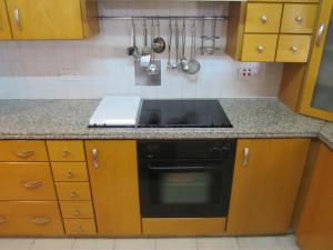 a kitchen with wooden cabinets and a stove top oven at Jasmine Residence in Nicosia