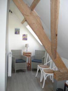 a living room with two chairs and a table at B&B Hoeve 't Geleed in Damme