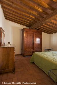 1 dormitorio con 1 cama y armario de madera en Centro Storico, en Casale Marittimo