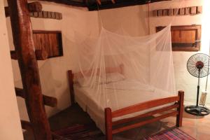 a bedroom with a canopy bed with a net at La Casita Nica in San Diego