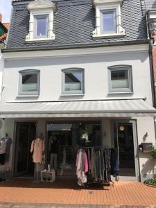 a store front of a white house with clothes on display at Captains Lounge in Eckernförde +3 photos
