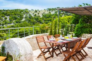 una mesa y sillas en un patio con vistas en Iconic Villas - Villa Vada, en Agia Efimia