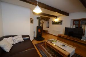 a living room with a leather couch and a tv at Holiday Home Natura in Bovec
