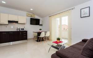 a living room and kitchen with a couch and a table at Apartments Hrgovcic in Baška