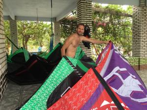 a shirtless man standing next to a bunch of kites at Green House in Prea