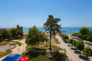 uma vista para uma rua com árvores e o oceano em LE MONDE Seaview Suites em Kallikrateia