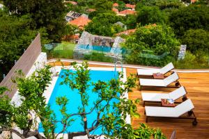 アギア・エフィミアにあるIconic Villas - Villa Vadaの木々が茂るデッキからスイミングプールを望めます。