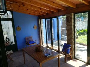 Zimmer mit einem Holztisch und einigen Fenstern in der Unterkunft Chalet con piscina privada, natural y acogedor in Chiclana de la Frontera