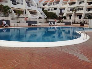 a large swimming pool in front of a building at New cozy flat with pool in amazing place..! in Costa Del Silencio