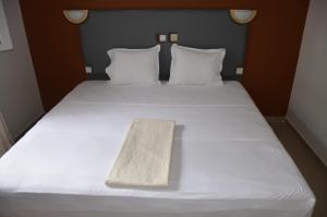 亚穆苏克罗Residence Heaven的一张铺有白色床单的床,上面有木制物品