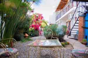 a table and chairs in a garden with flowers at Divina Presencia in Cafayate