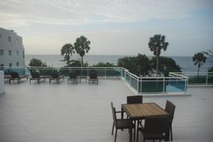 eine Terrasse mit Tischen und Stühlen und Meerblick in der Unterkunft E&J Beach Condo in Sosúa