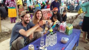 a man and woman sitting at a blue table with bottles at Binh Minh Hostel in Dồng Văn