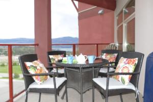 a table and chairs on a balcony with a view at Copper Oasis in West Kelowna