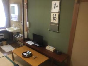 a bathroom with a desk with a computer on it at Ryokan Sarashinaya in Kiso