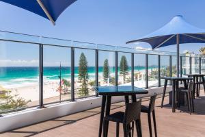 a balcony with tables and chairs and the beach at Holiday Holiday Soul Apartments in Gold Coast