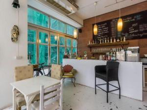a restaurant with a bar with a table and chairs at Oriental Smile Hotel in Bangkok